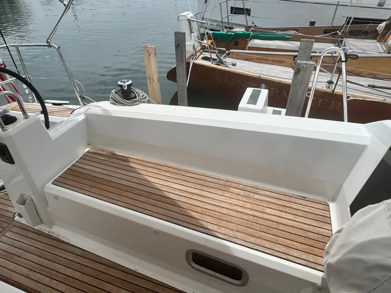 Slide: The Image of 2023 Beneteau Oceanis 38.1 yacht cockpit with dual steering wheels and teak flooring. - 7