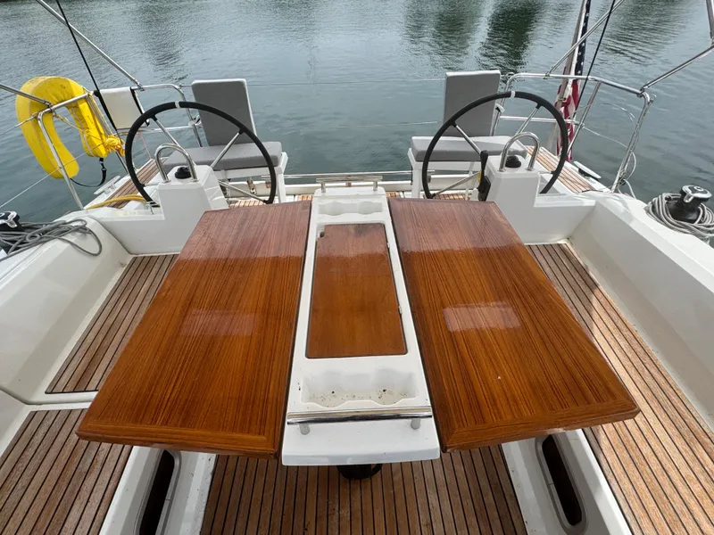 Slide: The Image of 2023 Beneteau Oceanis 38.1 sailboat cockpit with wooden seating and steering wheel. - 8