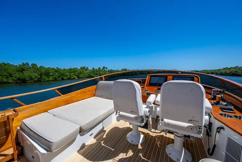 Slide: The Image of 2021 Hinckley Talaria 55 Flybridge MKII, luxurious deck with seating, scenic water view. - 15