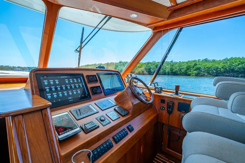 Slide: The Image of Helm of 2021 Hinckley Talaria 55 Flybridge MKII with advanced navigation systems and scenic view. - 21