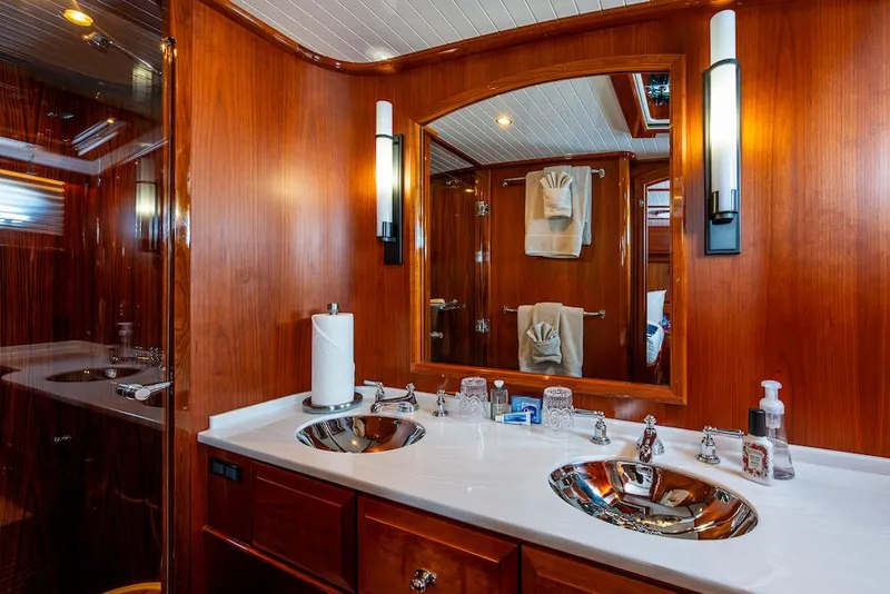 Slide: The Image of Luxurious bathroom in 2021 Hinckley Talaria 55 Flybridge MKII yacht with dual sinks and wood finish. - 30