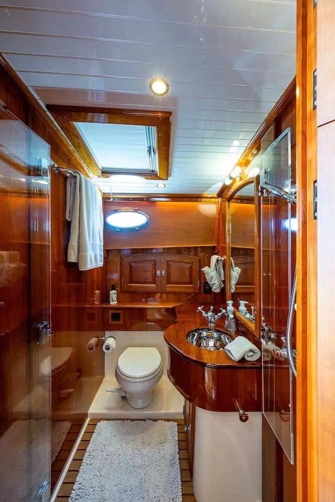 Slide: The Image of Luxurious bathroom in 2021 Hinckley Talaria 55 Flybridge MKII yacht with wood accents and modern fixtures. - 35