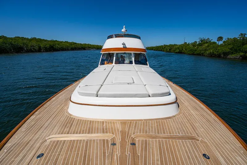 Slide: The Image of 2021 Hinckley Talaria 55 Flybridge MKII yacht on serene waterway, showcasing elegant design. - 6