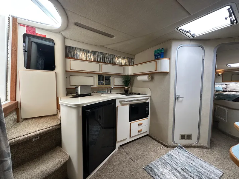 Slide: The Image of Interior of 1994 Sea Ray 370 Sundancer yacht, featuring kitchenette and cozy living space. - 10