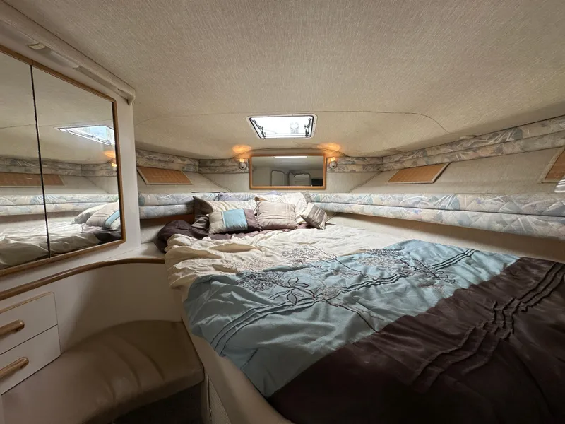 Slide: The Image of Cozy cabin interior of 1994 Sea Ray 370 Sundancer with bed and mirrored wall. - 14