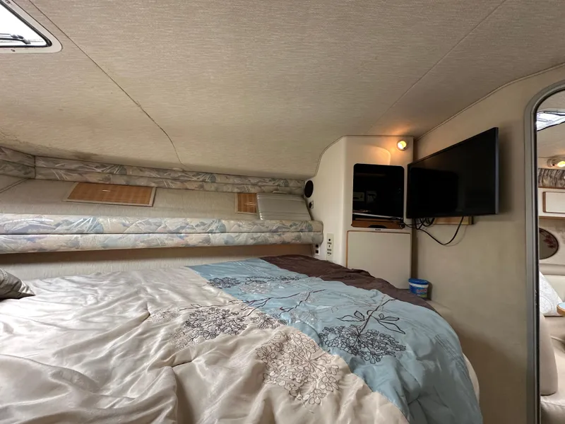Slide: The Image of Cozy cabin interior of 1994 Sea Ray 370 Sundancer with bed and TV. - 15