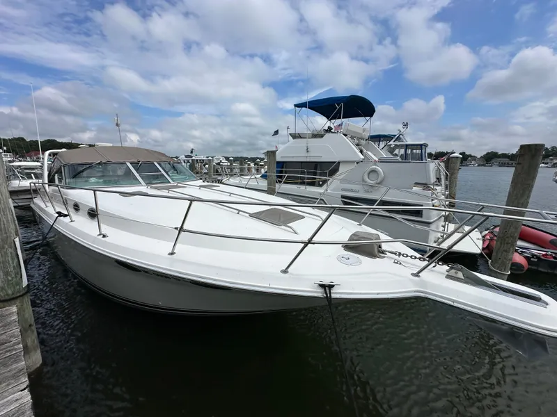 Slide: The Image of 1994 Sea Ray 370 Sundancer docked at a marina under a partly cloudy sky. - 2