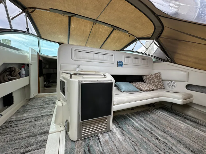 Slide: The Image of 1994 Sea Ray 370 Sundancer interior with seating, sink, and cushions under a canopy. - 4