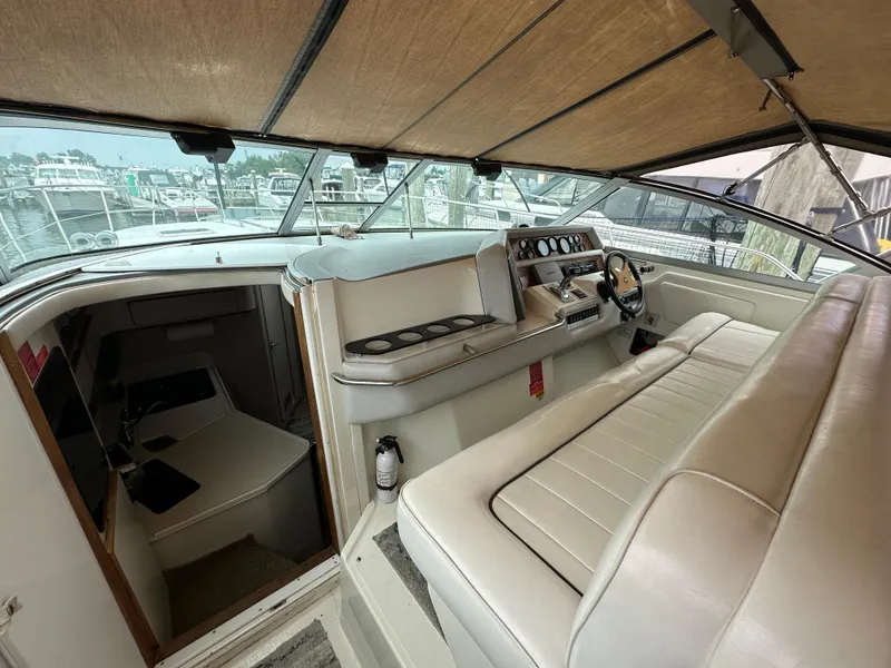 Slide: The Image of 1994 Sea Ray 370 Sundancer cockpit with helm, seating, and cabin entrance. - 5