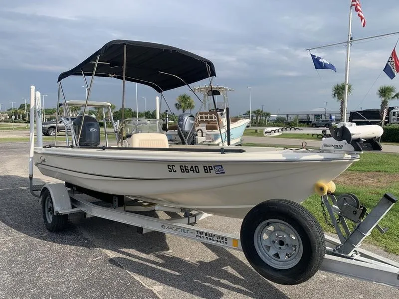 Slide: The Image of 2003 Scout 177 Sportfish boat on trailer with canopy, parked outdoors. - 6