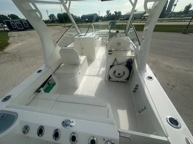 Slide: The Image of 2023 Edgewater 230CX boat anchor compartment with open hatch, showcasing anchor and winch system. - 11