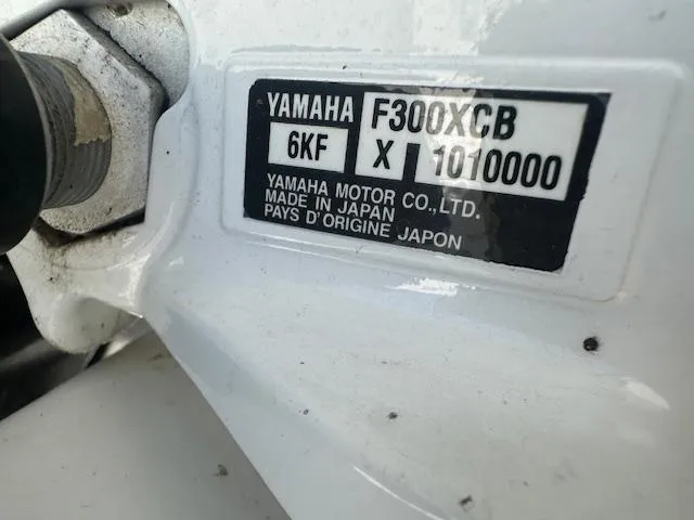 Slide: The Image of 2023 Edgewater 230CX boat on display outside a building under clear blue sky. - 6