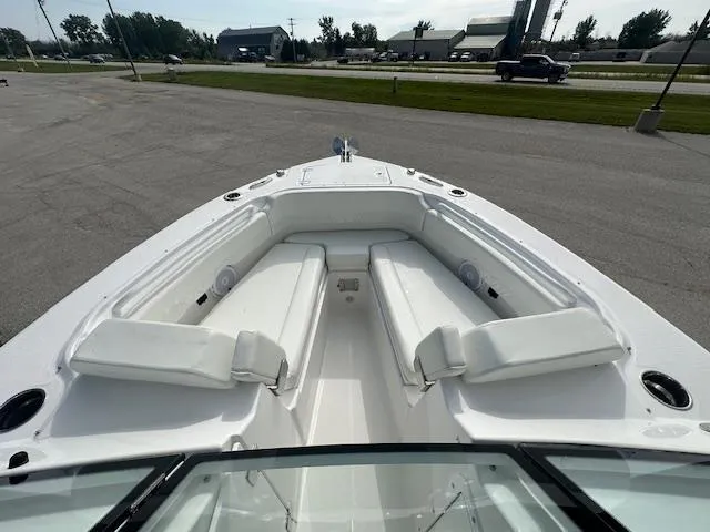Slide: The Image of 2023 Edgewater 230CX boat with outboard motor, viewed from the rear on a sunny day. - 9