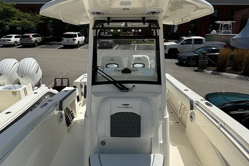 Slide: The Image of 2025 Cobia 265 Center Console boat in a parking lot, showcasing helm and seating area. - 14