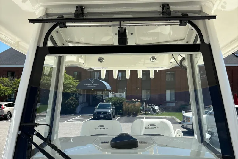 Slide: The Image of 2025 Cobia 265 Center Console boat interior view with windshield and seating. - 15