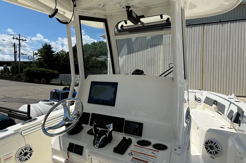 Slide: The Image of 2025 Cobia 265 Center Console boat interior with steering wheel and control panel. - 17