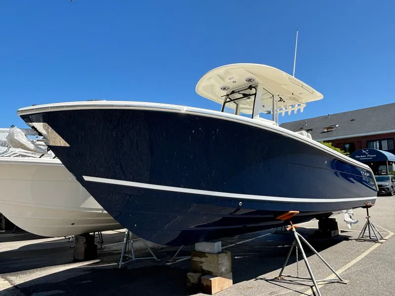 Slide: The Image of 2025 Cobia 265 Center Console boat on display, blue hull, outdoor setting. - 2