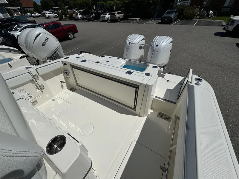 Slide: The Image of 2025 Cobia 265 Center Console boat with dual engines in a parking lot. - 29