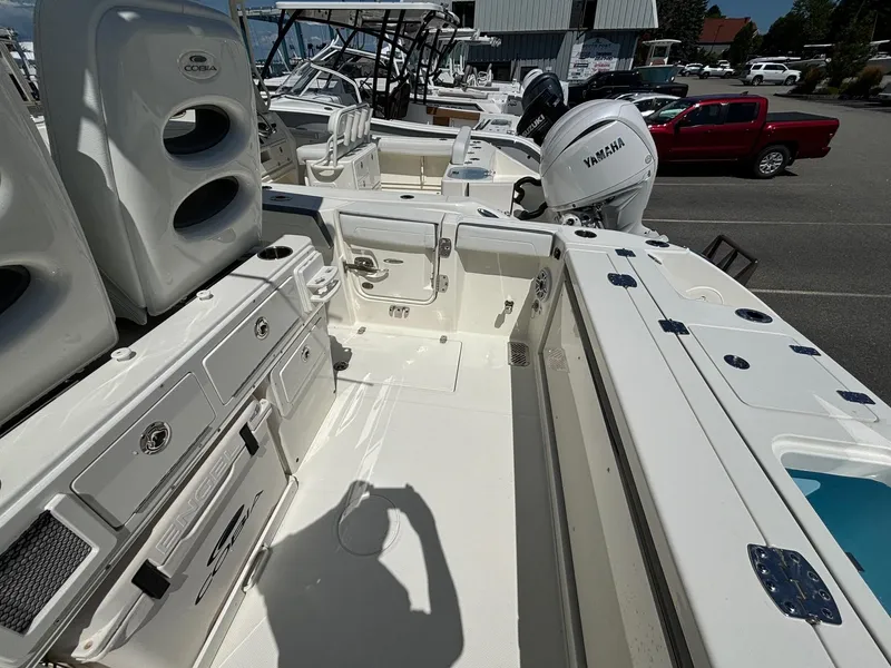 Slide: The Image of 2025 Cobia 265 Center Console boat interior with Yamaha engine, docked in a marina. - 30