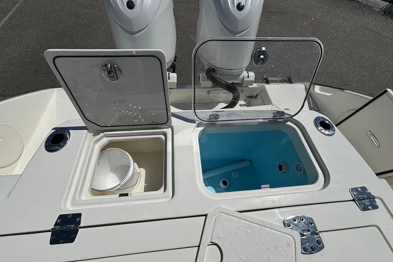 Slide: The Image of 2025 Cobia 265 Center Console boat with open storage compartments and dual engines. - 36
