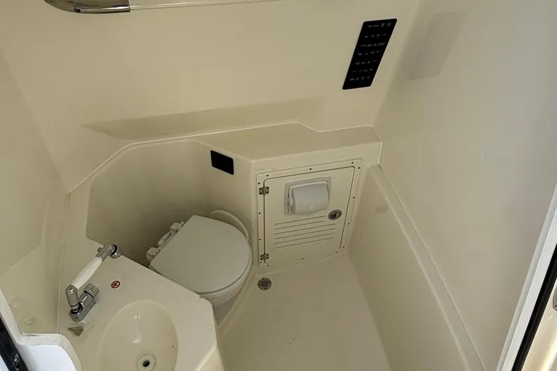 Slide: The Image of 2025 Cobia 265 Center Console boat interior with compact bathroom amenities. - 39