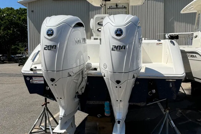 Slide: The Image of 2025 Cobia 265 Center Console with twin Yamaha 200 engines, displayed outdoors. - 5