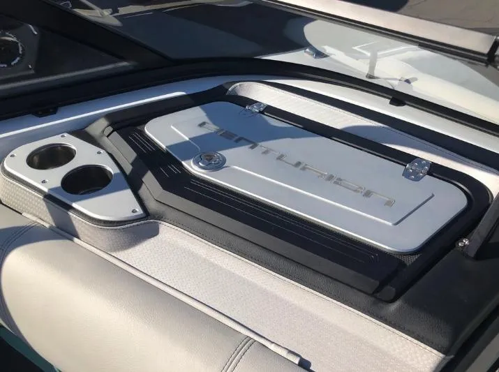 Slide: The Image of 2022 Centurion Ri 230 boat interior with cup holders and storage compartment. - 28