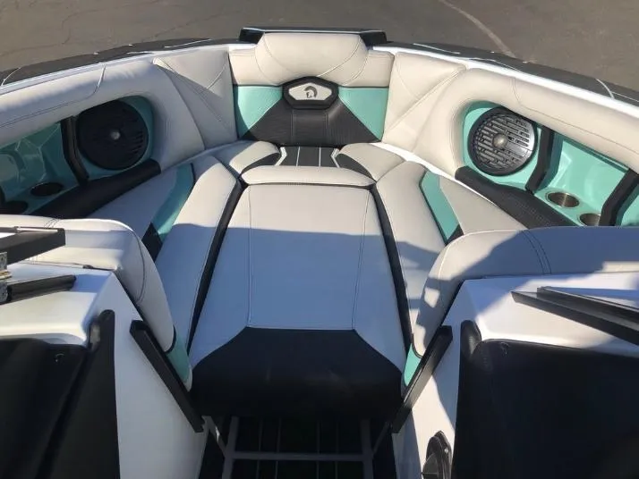 Slide: The Image of 2022 Centurion Ri 230 boat interior with teal and white seating, featuring built-in speakers. - 30