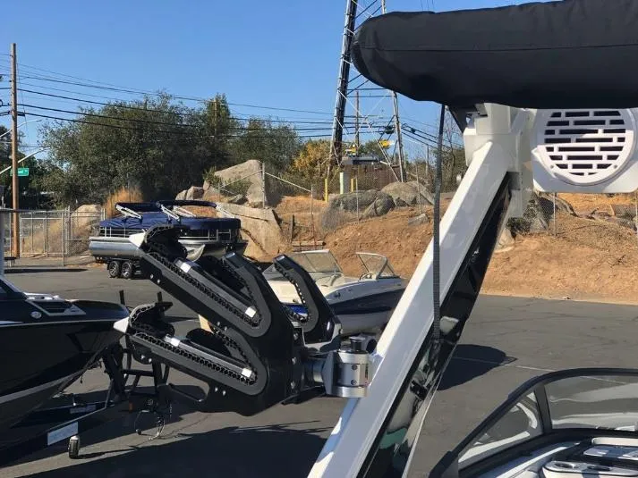 Slide: The Image of 2022 Centurion Ri 230 boat with wakeboard racks and speaker, parked outdoors. - 8