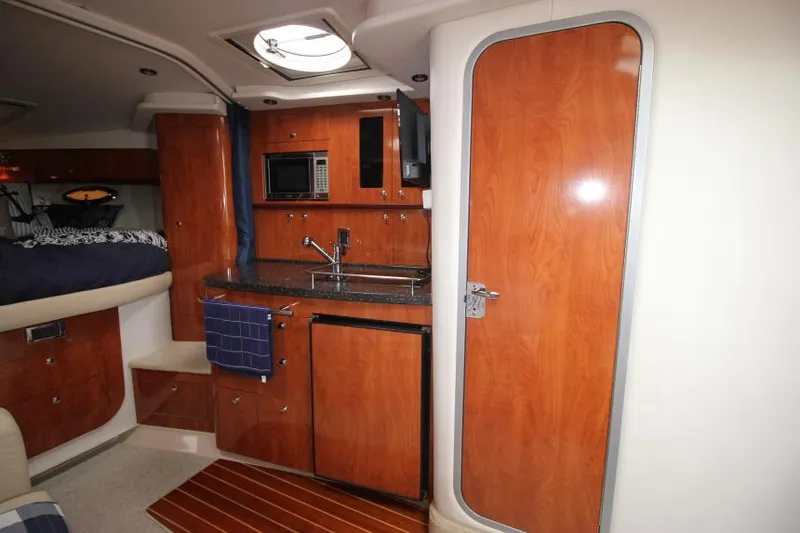 Slide: The Image of 2008 Four Winns V338 yacht interior with kitchenette, wood cabinetry, and modern amenities. - 26