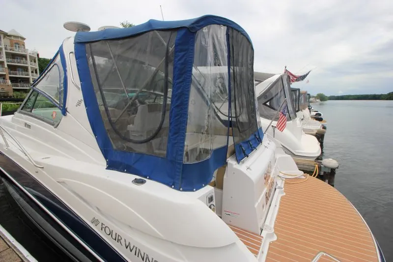 Slide: The Image of 2008 Four Winns V338 boat docked with blue canopy, adjacent to other boats. - 7