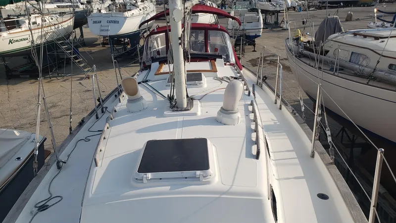 Slide: The Image of 1991 Pacific Seacraft 34 sailboat on dry dock, surrounded by other vessels. - 11