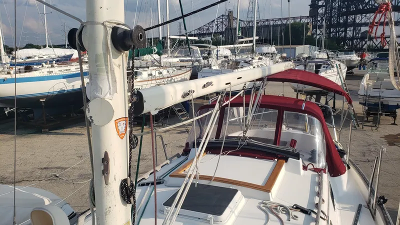 Slide: The Image of 1991 Pacific Seacraft 34 sailboat docked in a marina, featuring a red canopy and mast. - 12