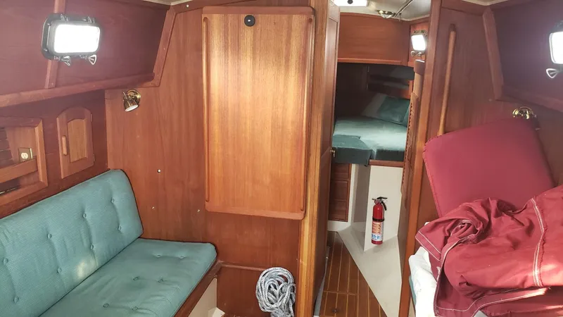 Slide: The Image of Interior of 1991 Pacific Seacraft 34 sailboat with wooden cabinetry and teal seating. - 14