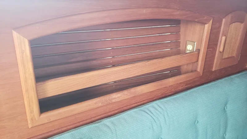 Slide: The Image of Wooden interior detail of a 1991 Pacific Seacraft 34 sailboat with teal upholstery. - 15