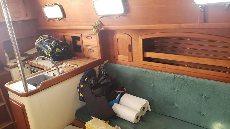 Slide: The Image of Interior of 1991 Pacific Seacraft 34 sailboat with wooden cabinetry and green seating. - 19