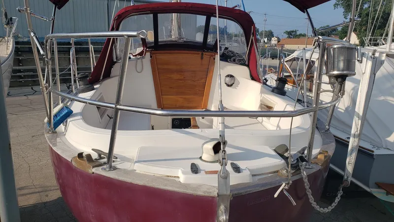 Slide: The Image of 1991 Pacific Seacraft 34 sailboat with maroon hull and stainless steel railings. - 6