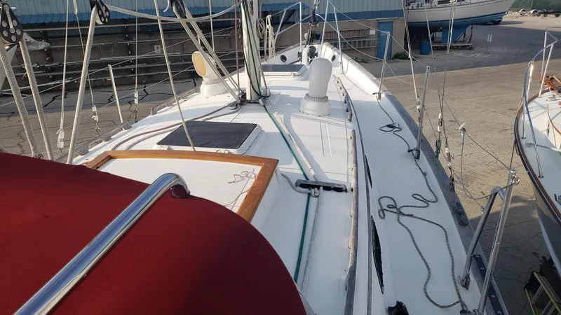 Slide: The Image of 1991 Pacific Seacraft 34 sailboat deck with rigging and red cover. - 8