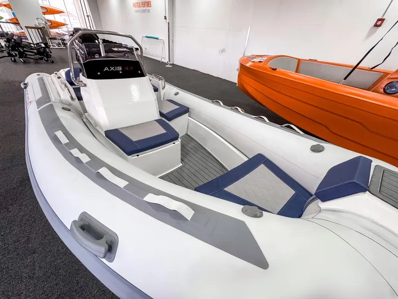 Slide: The Image of 2023 Northstar Axis 4.2 inflatable boat displayed indoors, featuring sleek design and seating. - 2