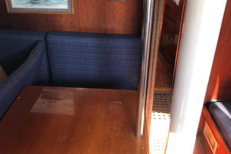 Slide: The Image of 1972 Fastnet Le Comte yacht interior with wooden table and blue seating. - 11