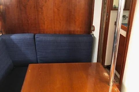 Slide: The Image of 1972 Fastnet Lecomte yacht interior with wooden table and blue cushioned seating. - 15