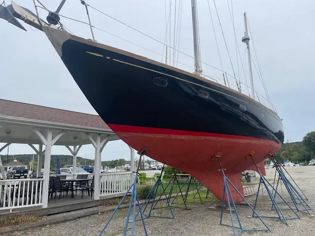 Slide: The Image of 1972 Fastnet Le Comte sailboat on stands, black hull with red bottom, outdoor display. - 2