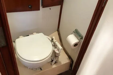 Slide: The Image of 1972 Fastnet Lecomte boat bathroom with compact toilet and toilet paper holder. - 20