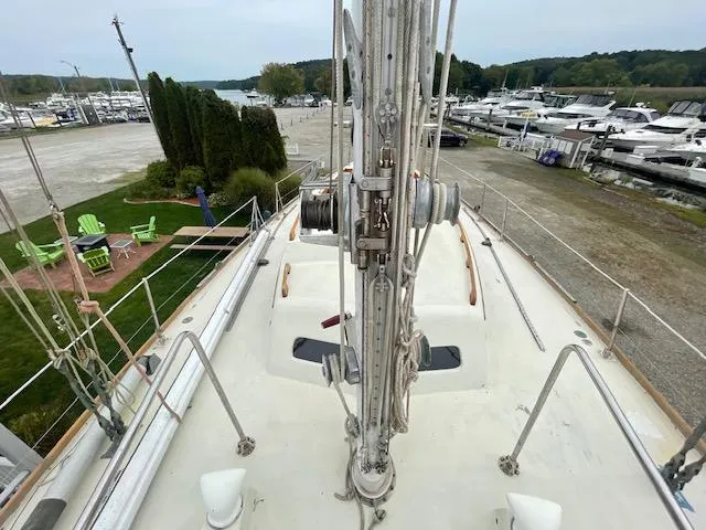 Slide: The Image of 1972 Fastnet Lecomte sailboat deck view at marina with surrounding boats and greenery. - 24