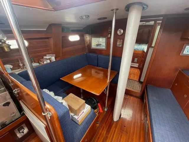 Slide: The Image of Interior of 1972 Fastnet Le Comte sailboat with wooden furnishings and blue seating. - 4