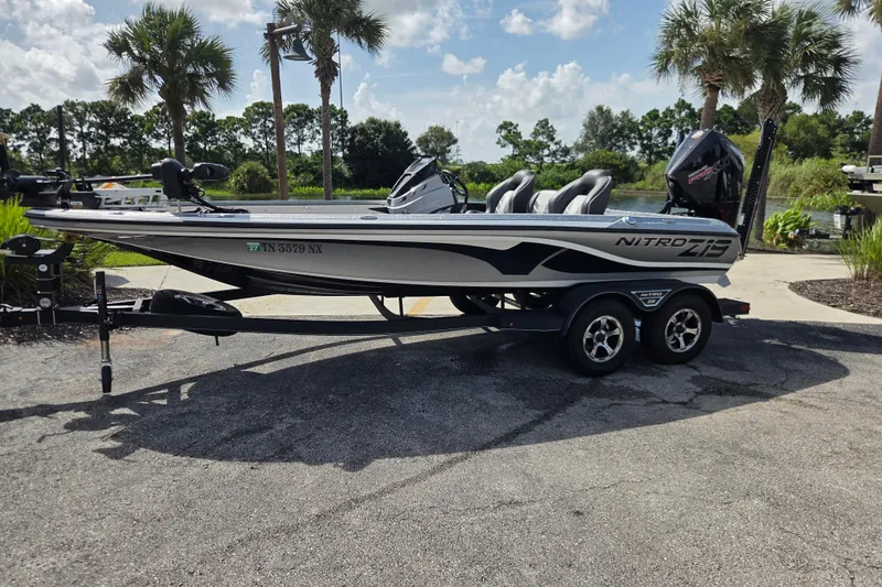 The Image of 2023 Nitro Z19 Pro boat on trailer, parked near palm trees under a sunny sky. - 0