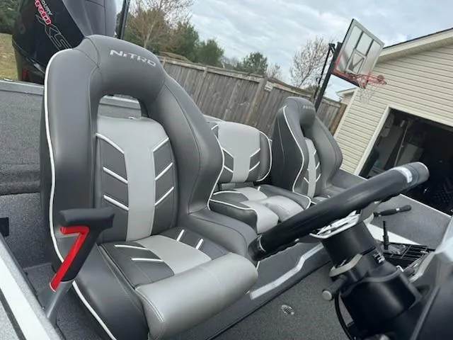 Slide: The Image of 2023 Nitro Z19 Pro boat seats with steering wheel, parked near a garage and basketball hoop. - 7