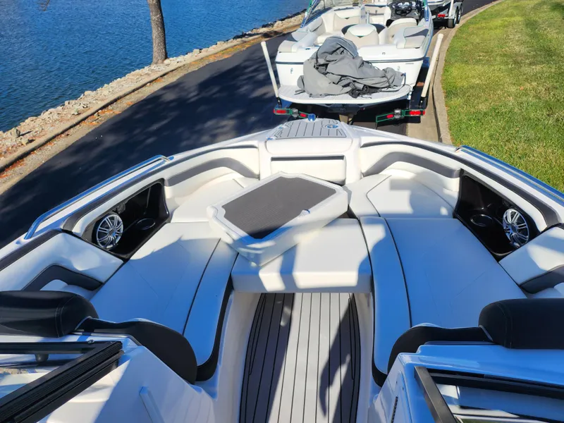 Slide: The Image of 2016 Yamaha Boats 242 Limited S interior with seating, docked by a lake. - 16