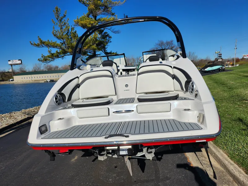 Slide: The Image of 2016 Yamaha Boats 242 Limited S, rear view by a lake, sunny day. - 2