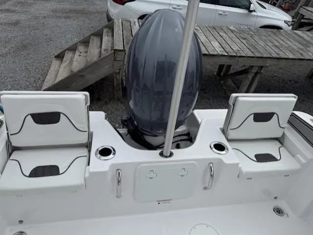 Slide: The Image of 2025 Wellcraft 202 Fisherman boat with seating and outboard motor, docked near wooden benches. - 10